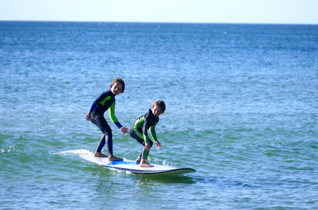 Butter's founding brothers surfing together on one board.